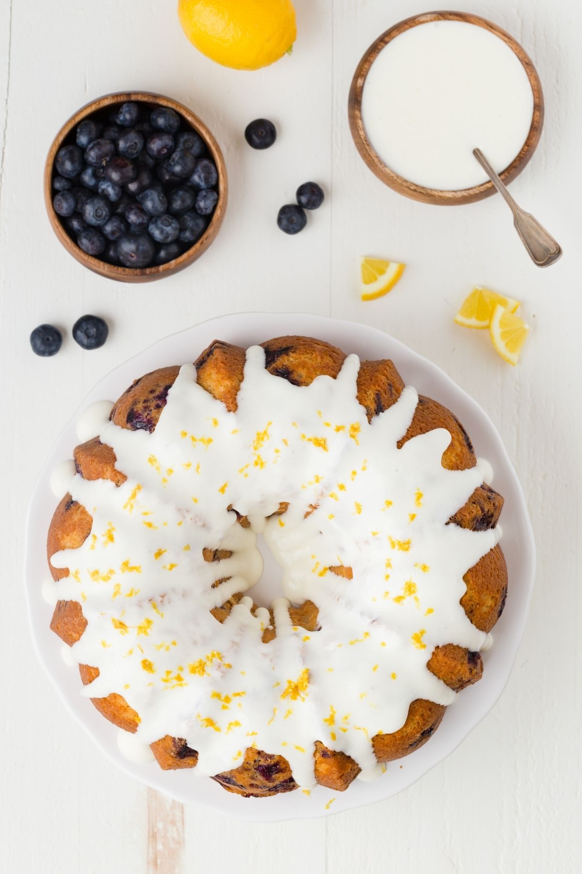 glazed lemon blueberry bundt cake on a white plate