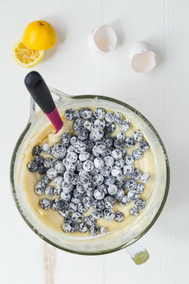 Cake batter in a bowl with blueberries.