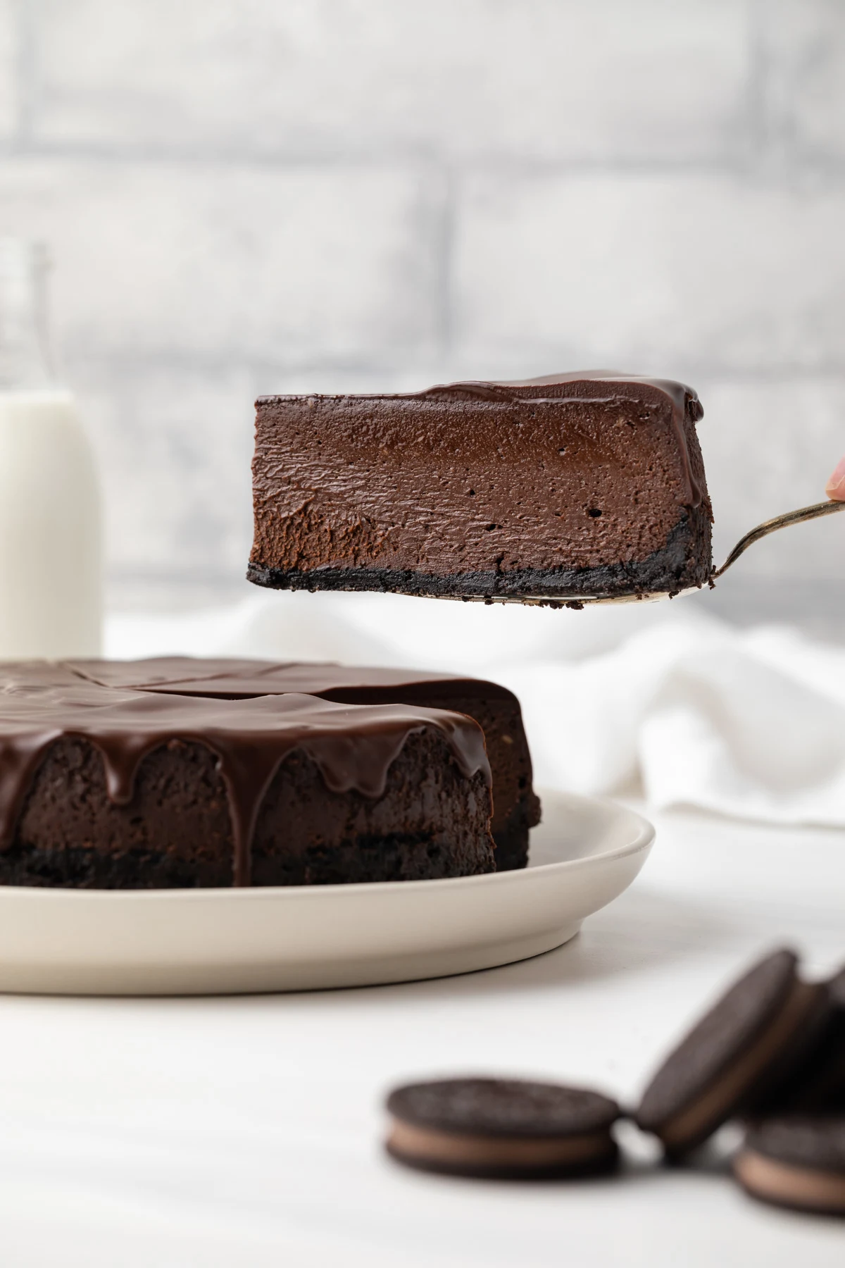 Side view of triple chocolate cheesecake on a white plate.