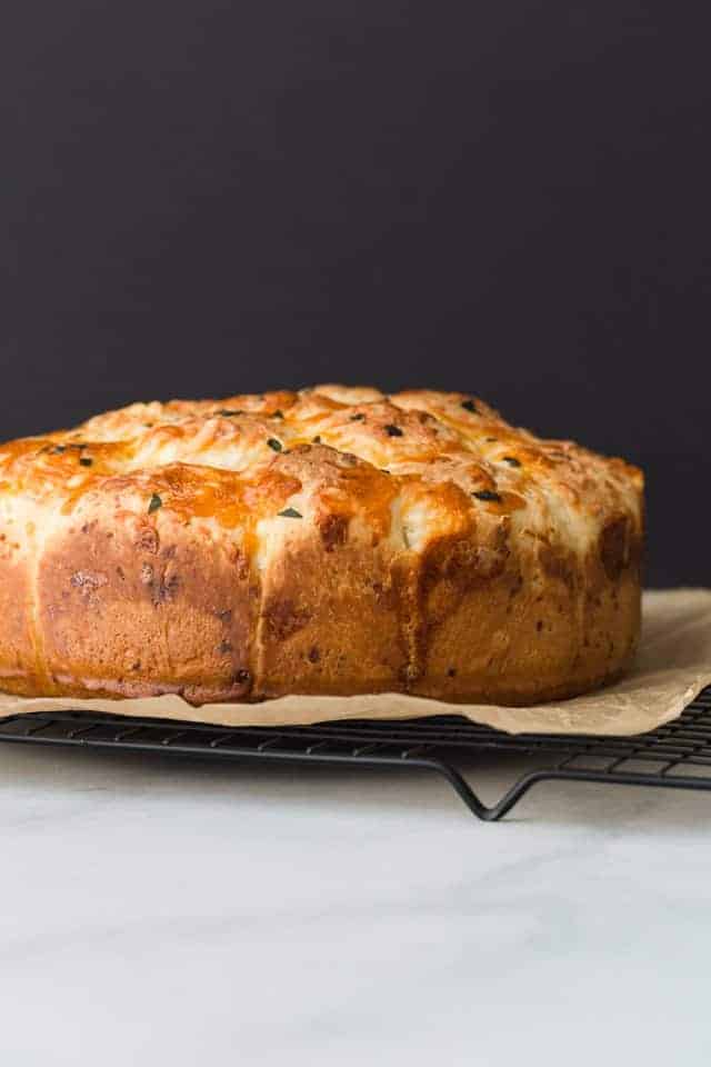 side view of Cheesy Garlic Pull Apart Rolls on a wire rack