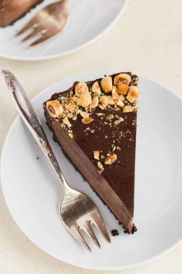 A slice of no bake Nutella cheesecake on a white plate with a fork next to it.