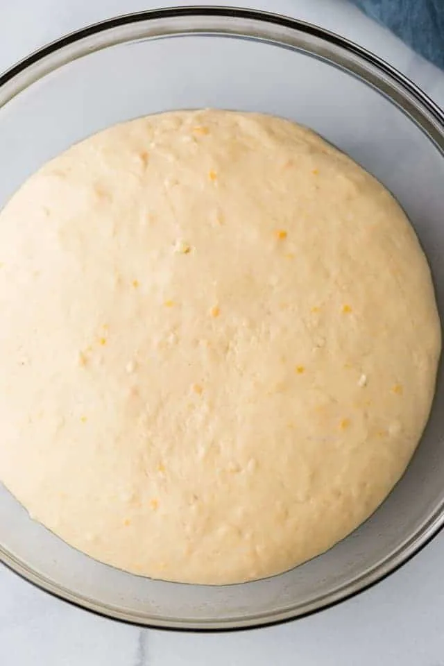 risen yeast dough in glass bowl