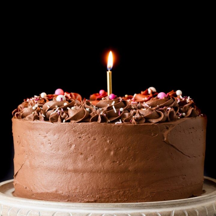 Classic Birthday Cake on a marble cake stand with a wooden base