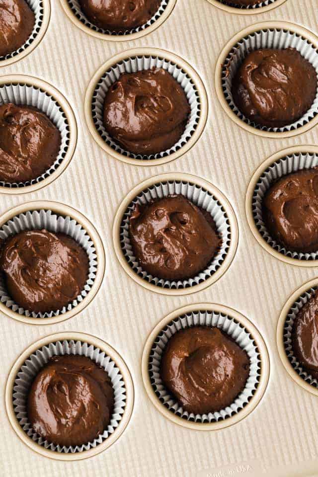 chocolate cupcake batter in paper lined muffin pan