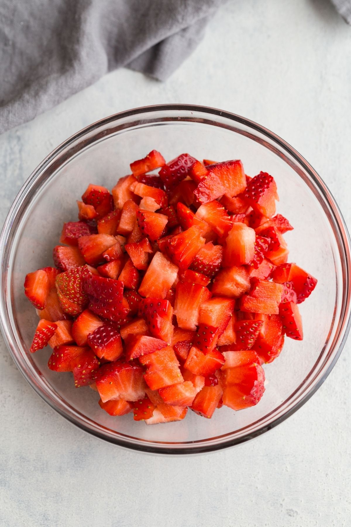 Diced strawberries in glass bowl.