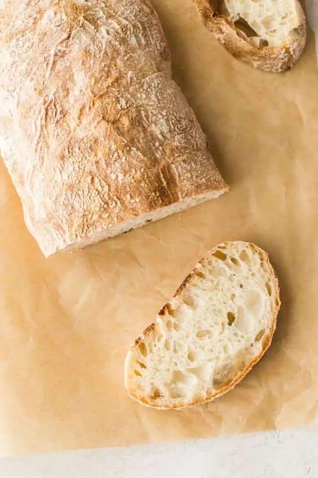 Easy Homemade Ciabatta Bread sliced on a piece of brown parchment paper.