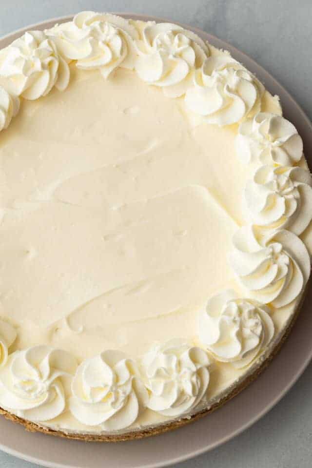 whole easy no bake cheesecake on white serving plate