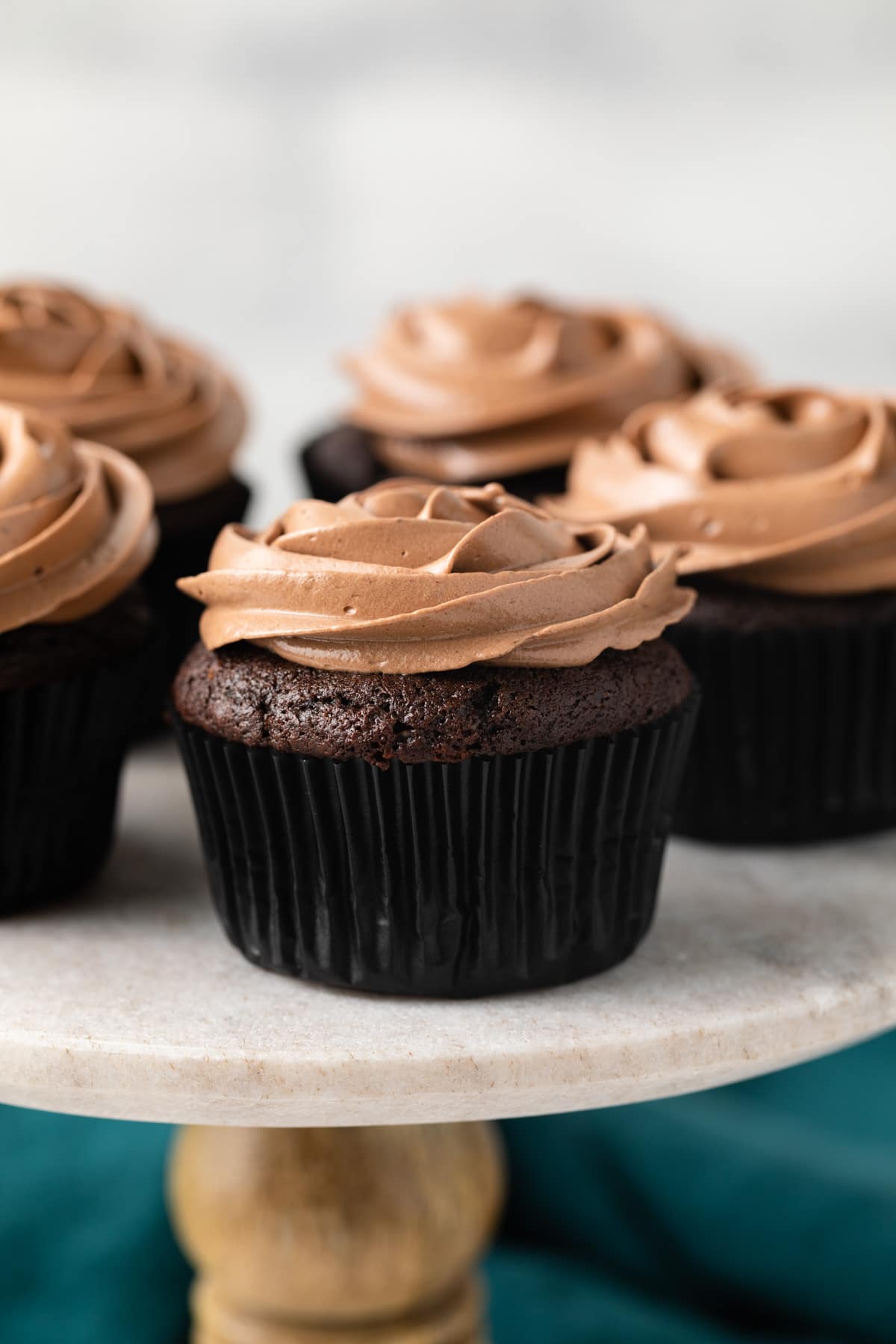 Best Chocolate Cupcakes on a marble cake stand.