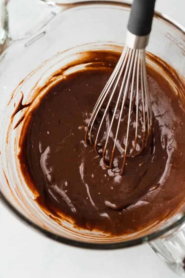 melted chocolate whisked into wet ingredients in glass bowl