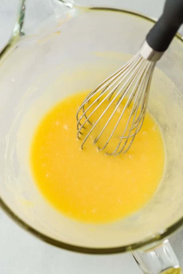 eggs whisked into wet ingredients in glass bowl