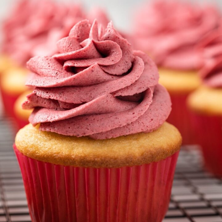 Raspberry frosting swirled over a yellow cupcake.
