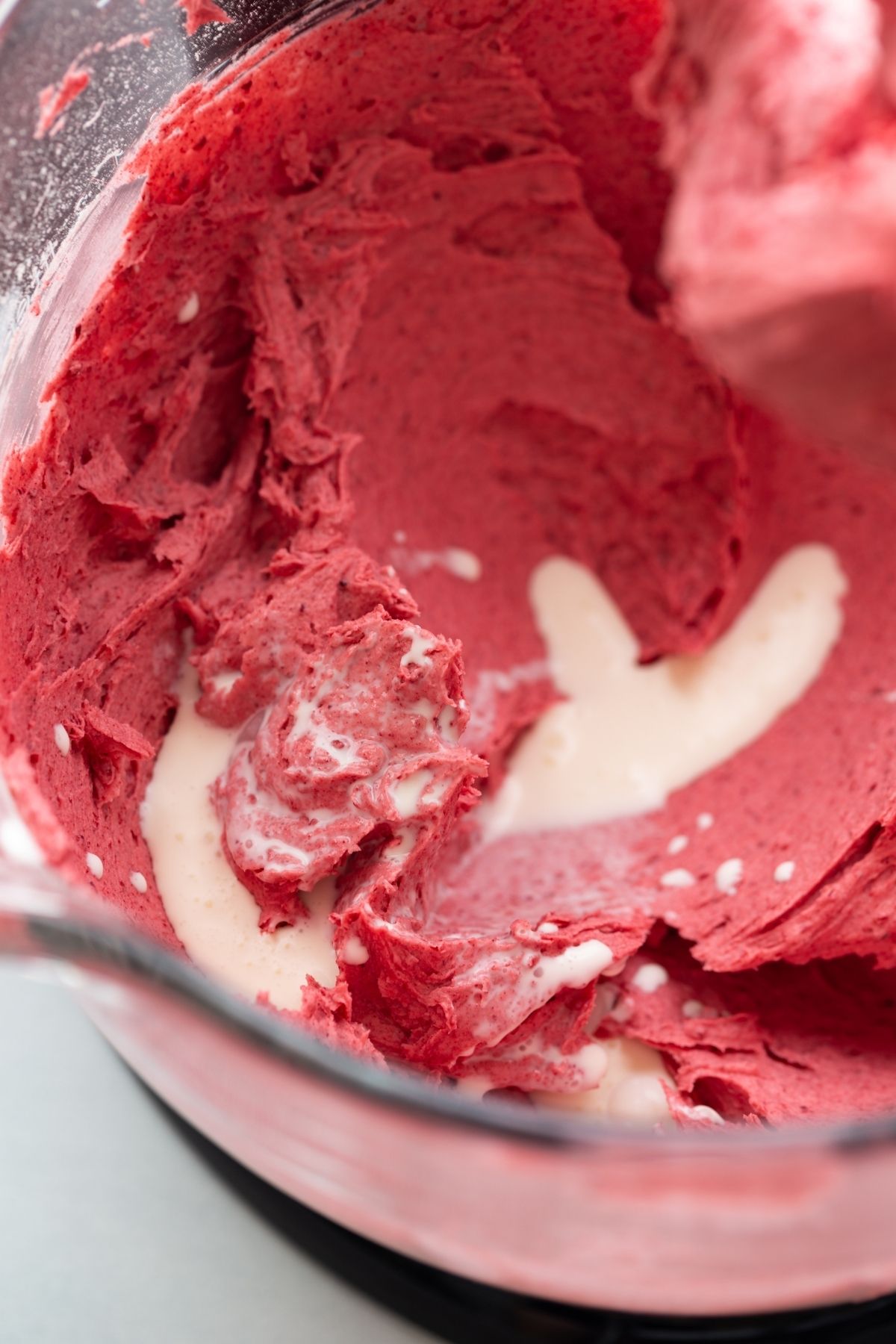 raspberry frosting with heaving cream in a mixing bowl
