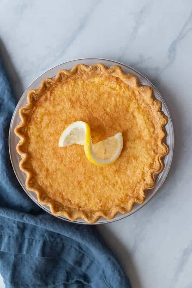 Overhead view of lemon chess pie with a lemon slice on top.