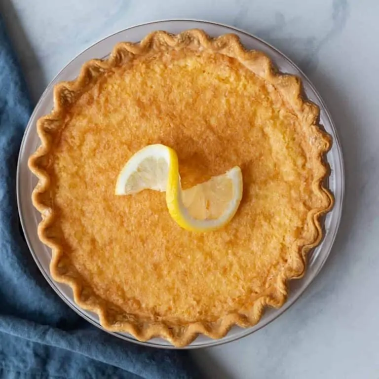 Overhead view of lemon chess pie with a lemon slice on top.