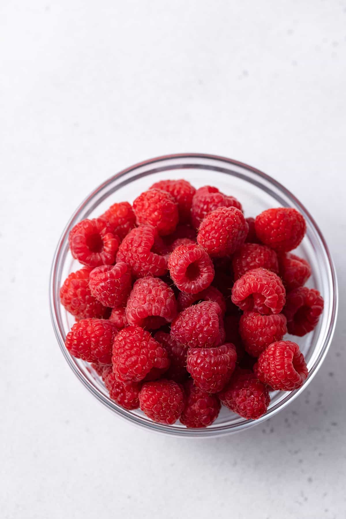 A glass bowl of fresh raspberries