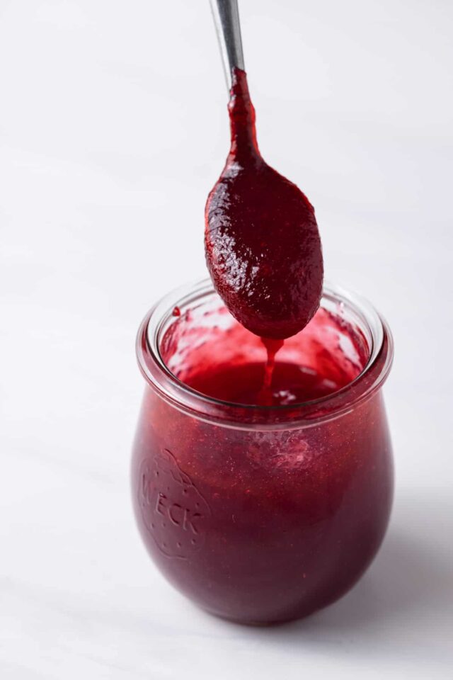 Raspberry jam in a jar with a spoon