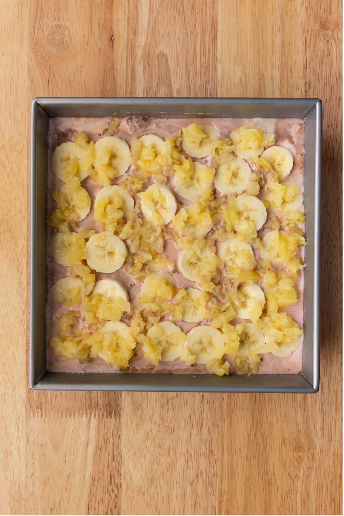Ice cream layered with banana slices and crushed pineapple.