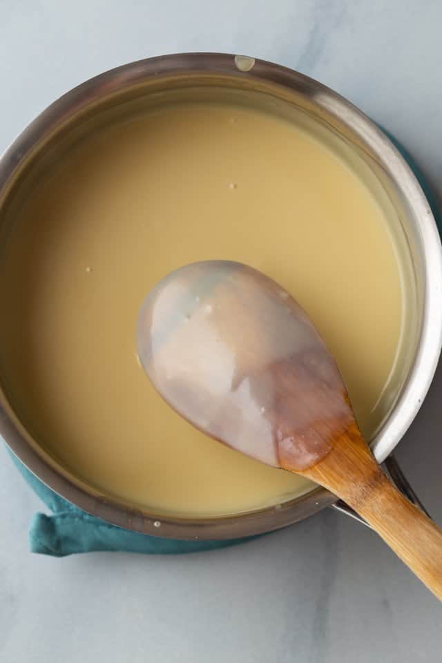 custard filling for honey pie in a saucepan with wooden spoon
