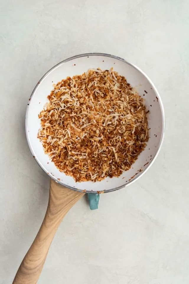 toasted coconut in a white fry pan