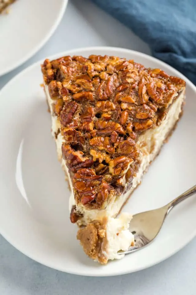 high angle view of pecan pie cheesecake with a fork taking a bite out