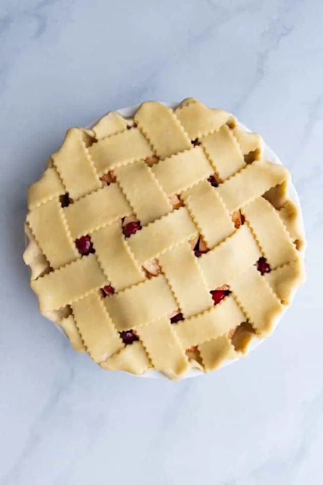 overhead view of an unbaked apple cranberry pie with a lattice crust