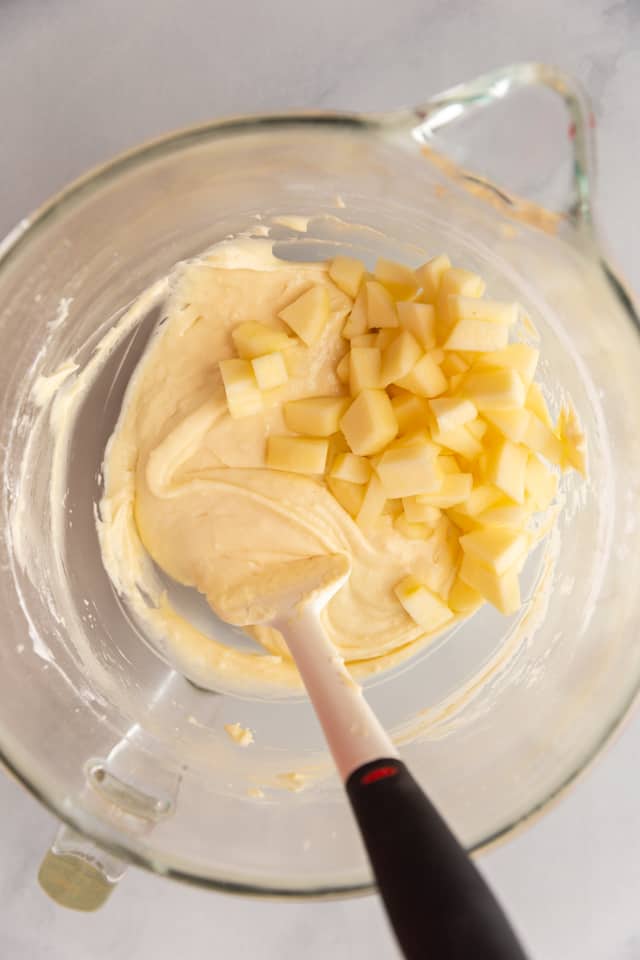 overhead view of apple cake batter in a glass bowl
