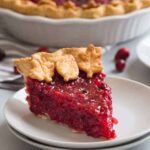 side view of a slice of cranberry pie on a white plate