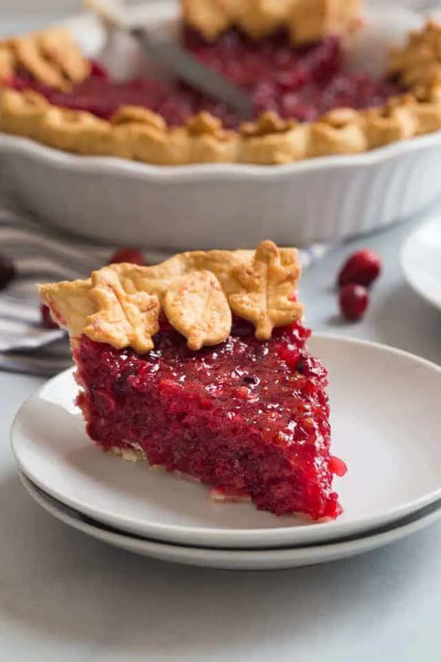 side view of a slice of cranberry pie on a white plate