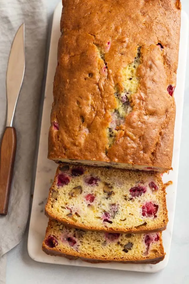 overhead view of cranberry walnut bread sliced on a cutting board