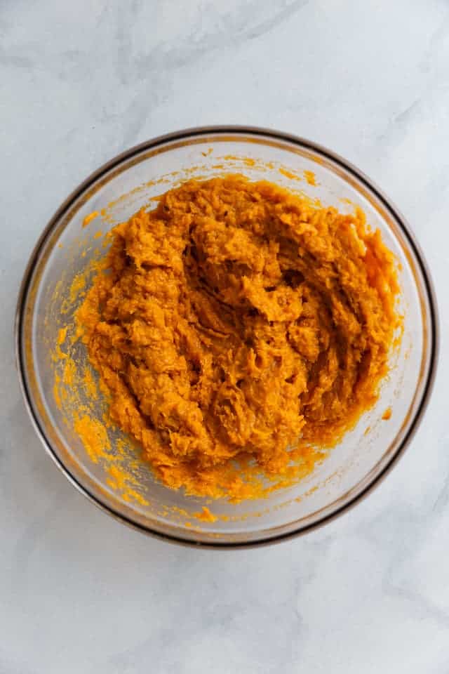 overhead view of mashed sweet potato in a glass bowl