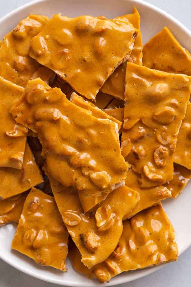 overhead view of peanut brittle on white plate