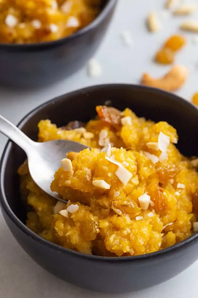 side view of pumpkin coconut halwa in a black bowl