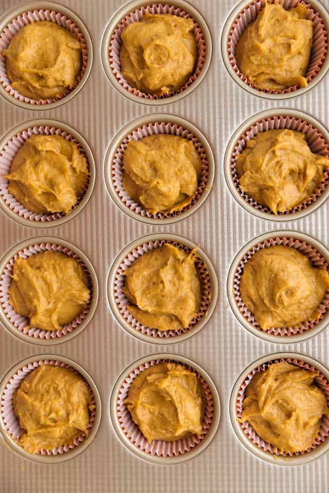 overhead view of unbaked pumpkin muffins in a baking pan