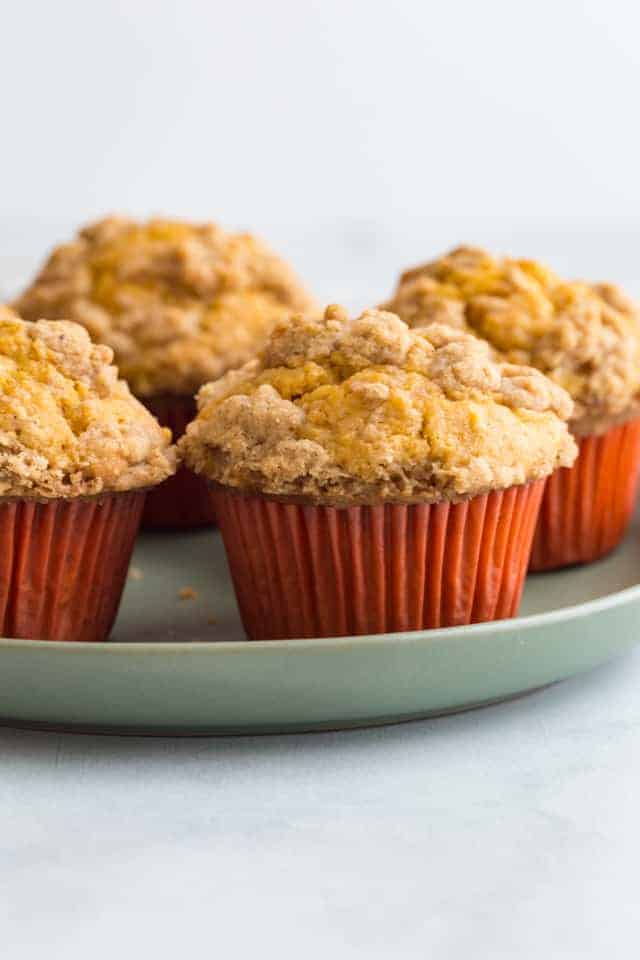 side view of pumpkin muffins on a green plate