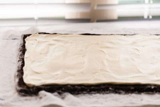 frosting slathered over thin chocolate cake for yule log