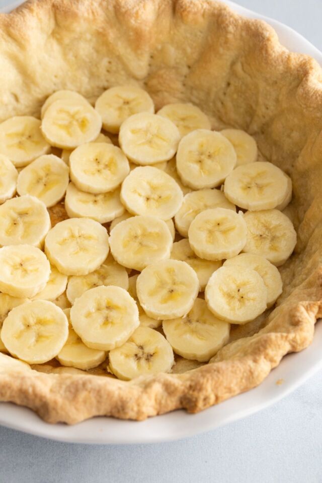 Bananas layered in the bottom of a baked pie shell.