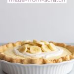 Side view of banana cream pie in a white pie dish with recipe name printed across the top.