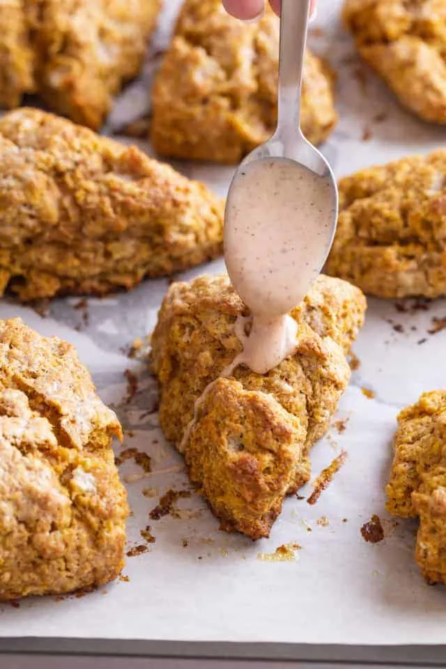 spiced glaze being drizzled over pumpkin scones