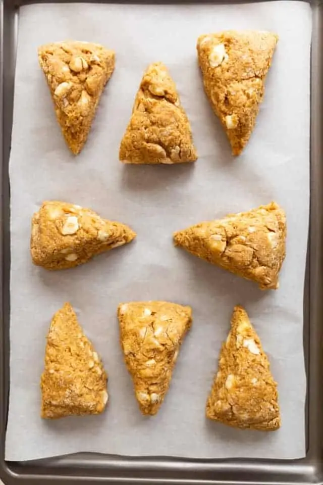 overhead view of unbaked pumpkin scones on a baking sheet