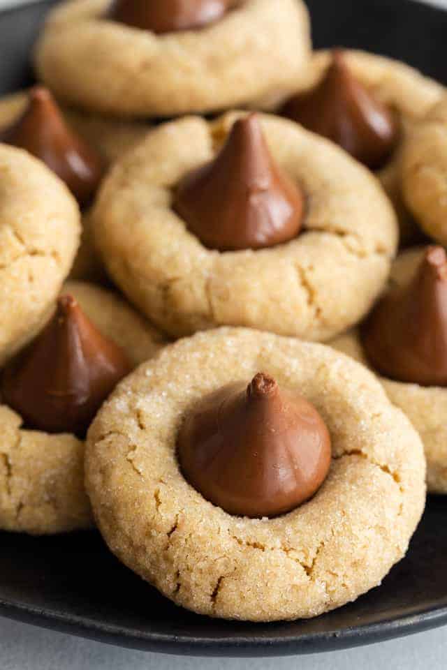 close up of peanut butter blossoms on black plate
