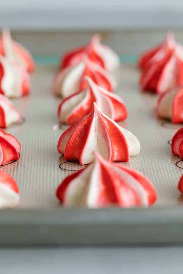 side view of peppermint meringue cookies on a baking sheet