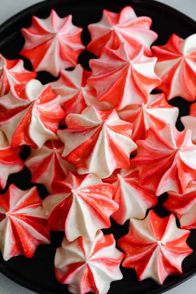 peppermint meringue cookies scattered on black plate