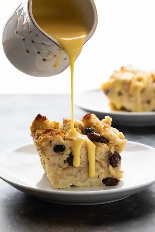 Bread pudding being drizzle with bread pudding sauce