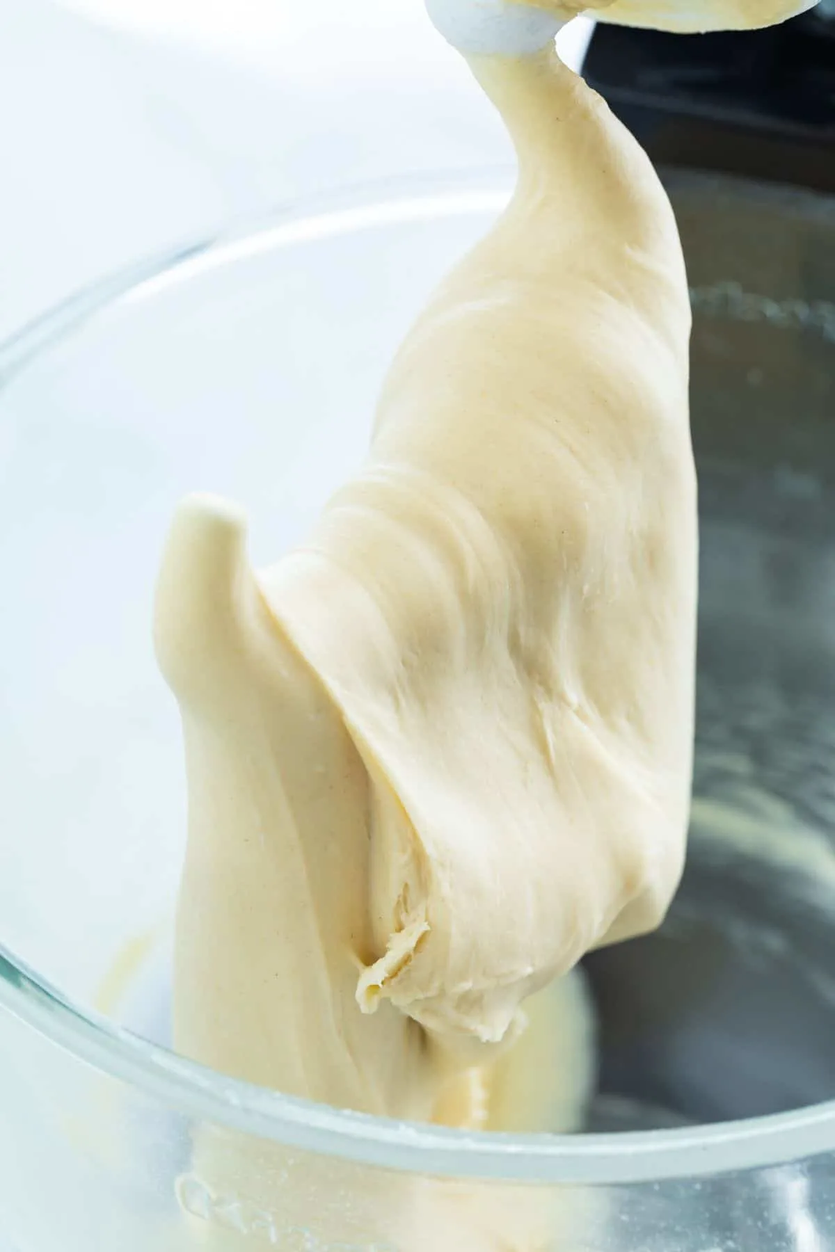 Homemade croissant dough on a dough hook of a stand mixer