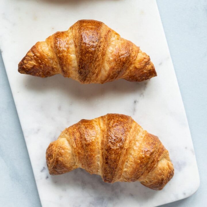 Overhead view of three croissants on a marble slab