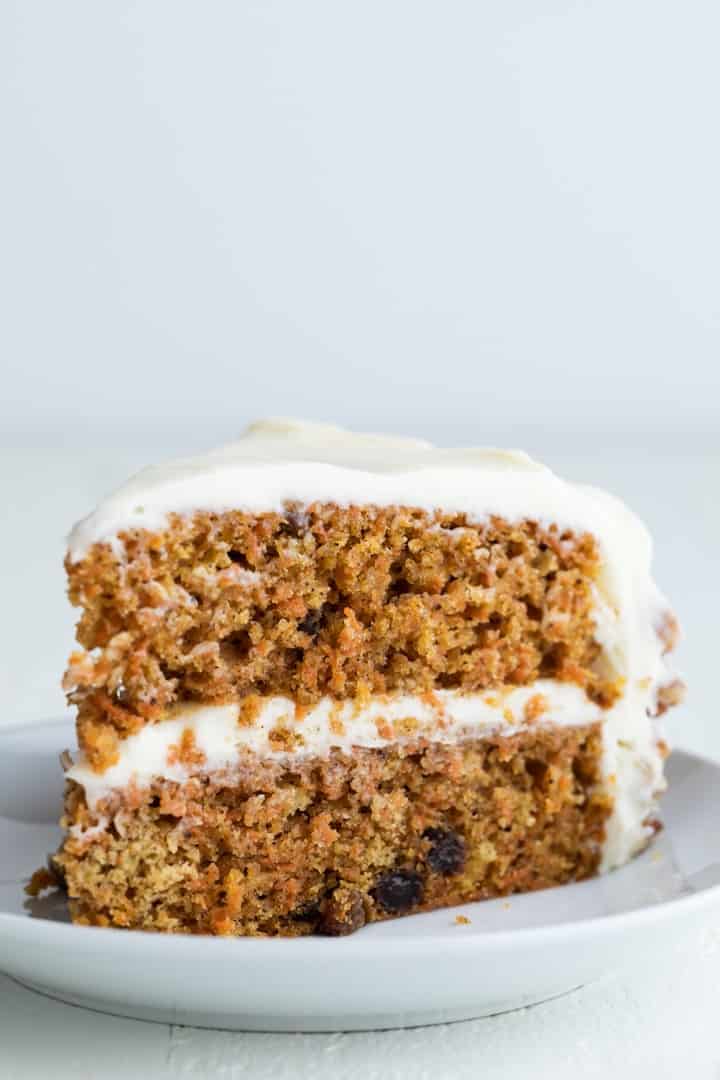 side view of carrot cake slice on white plate