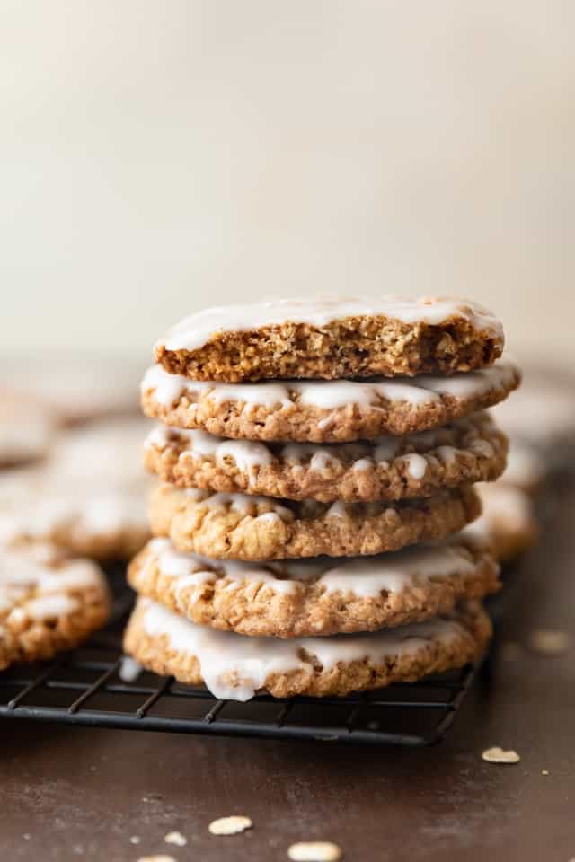 iced oatmeal cookies stacked on wire rack