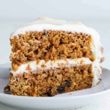 side view of carrot cake slice on white plate