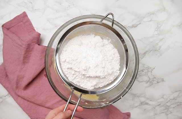 flour being sifted into cake batter