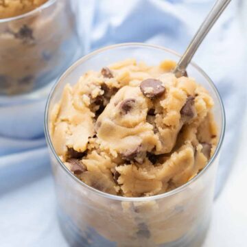 edible cookie dough in a glass cup with a spoon
